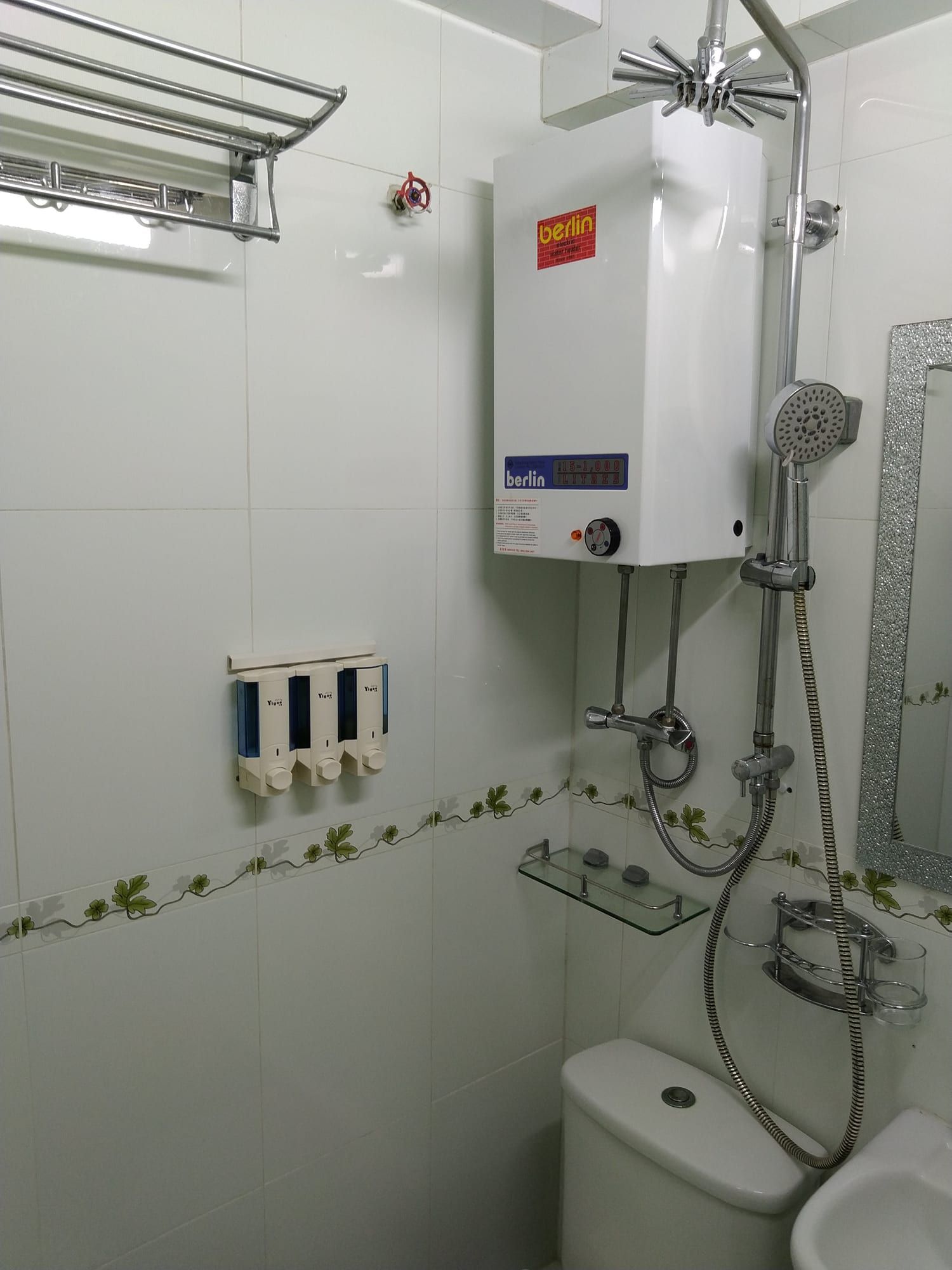 浴室：掛牆熱水爐、花灑柱上的花灑頭及手提花灑、三個梘液機、毛巾架、玻璃層架和閃石框鏡子，下方是座廁水箱和洗手盆。